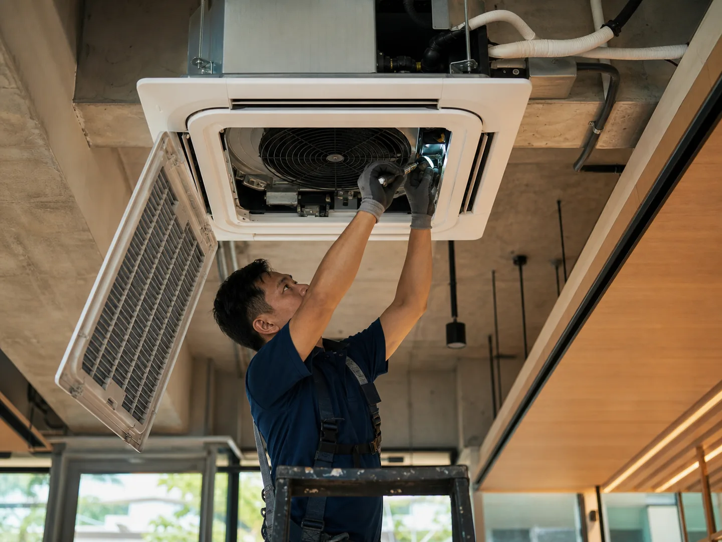 HVAC installer commissioning a ceiling cassette air-conditioning unit